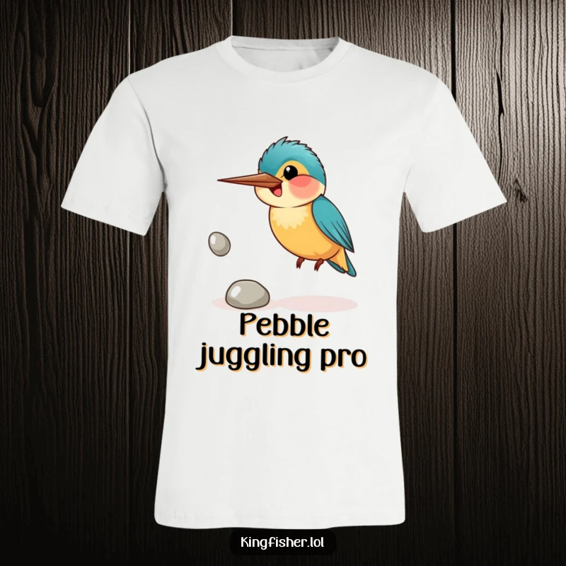Funny t-shirt featuring a smiling kingfisher bird awkwardly juggling three shiny pebbles, highlighting effort and good cheer.
